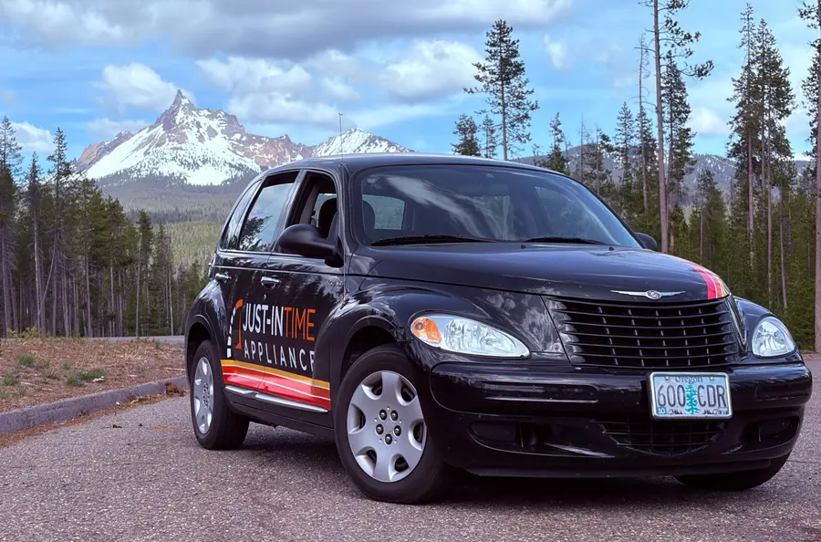 Just-in Time branded PT Cruiser parked with a snow-capped Oregon mountain in the background