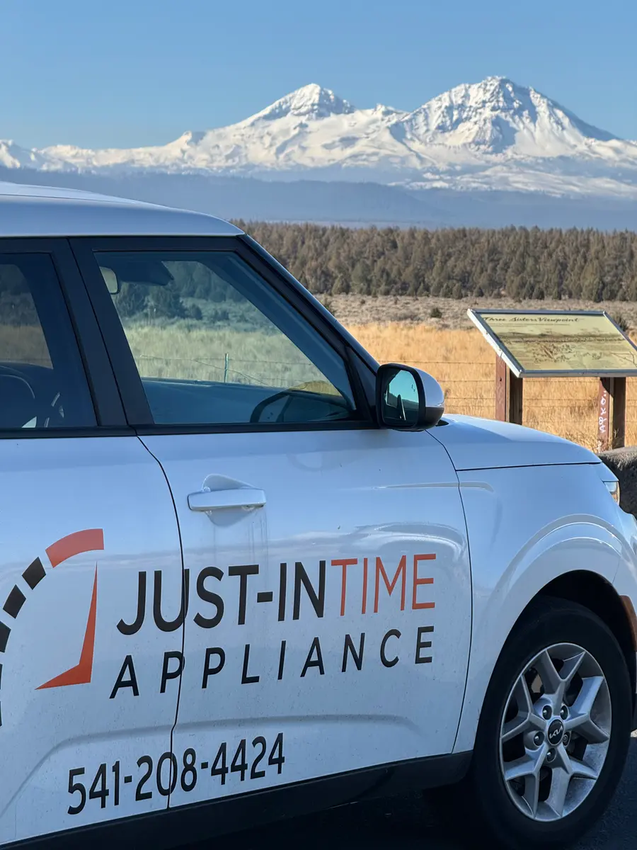 Just-in Time branded Kia Soul at the Three Sisters Viewpoint with snowy peaks behind it