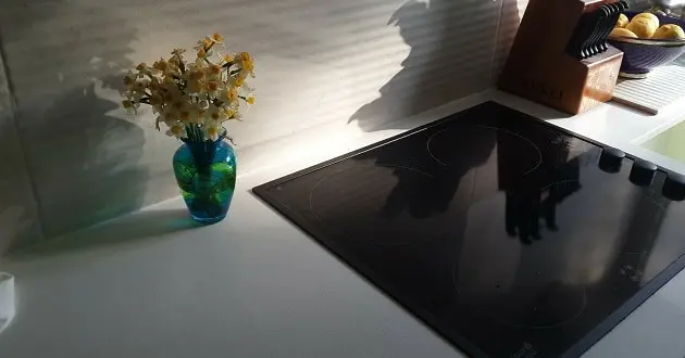 Clean black glass cooktop on a white kitchen counter