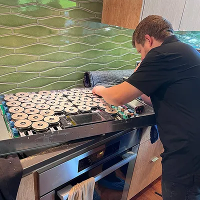 Technician repairing a luxury range cooktop