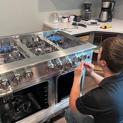 Technician diagnosing a gas range