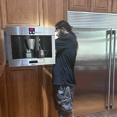 Technician repairing a built-in coffee maker