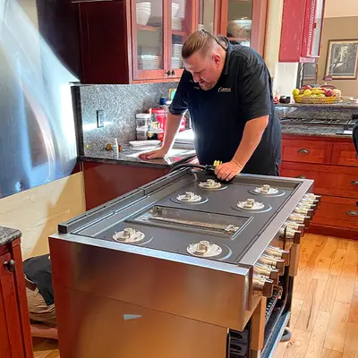 Technician repairing a large professional range