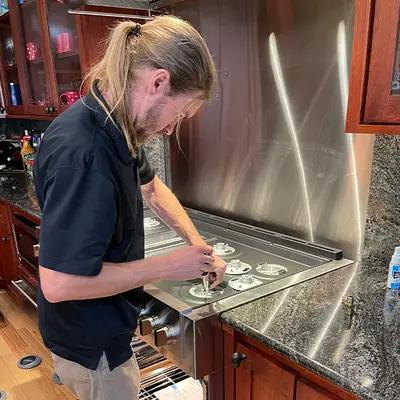 Technician repairing an induction cooktop
